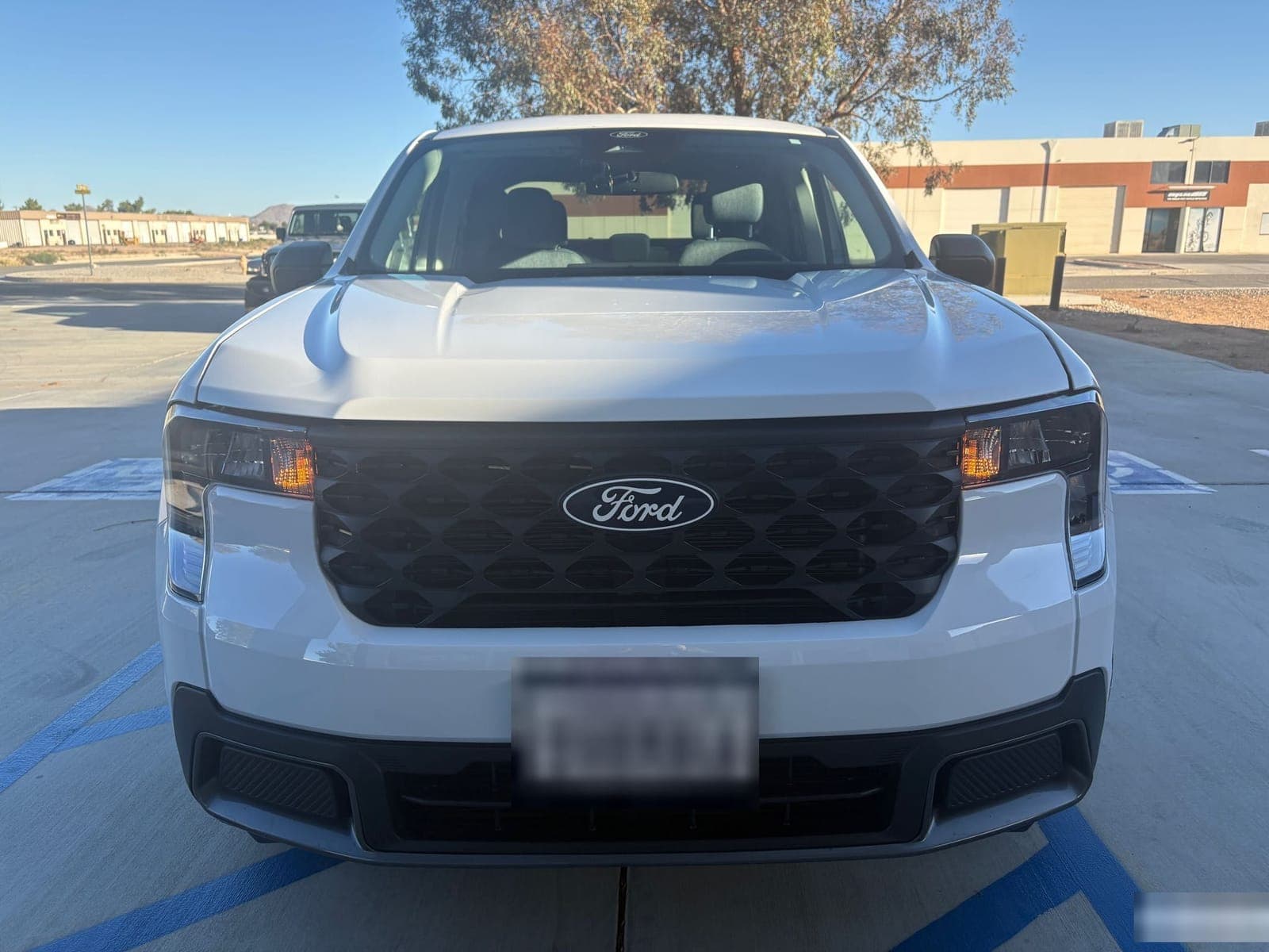 The same white Ford Maverick after repair, with a clean front bumper and aligned hood
