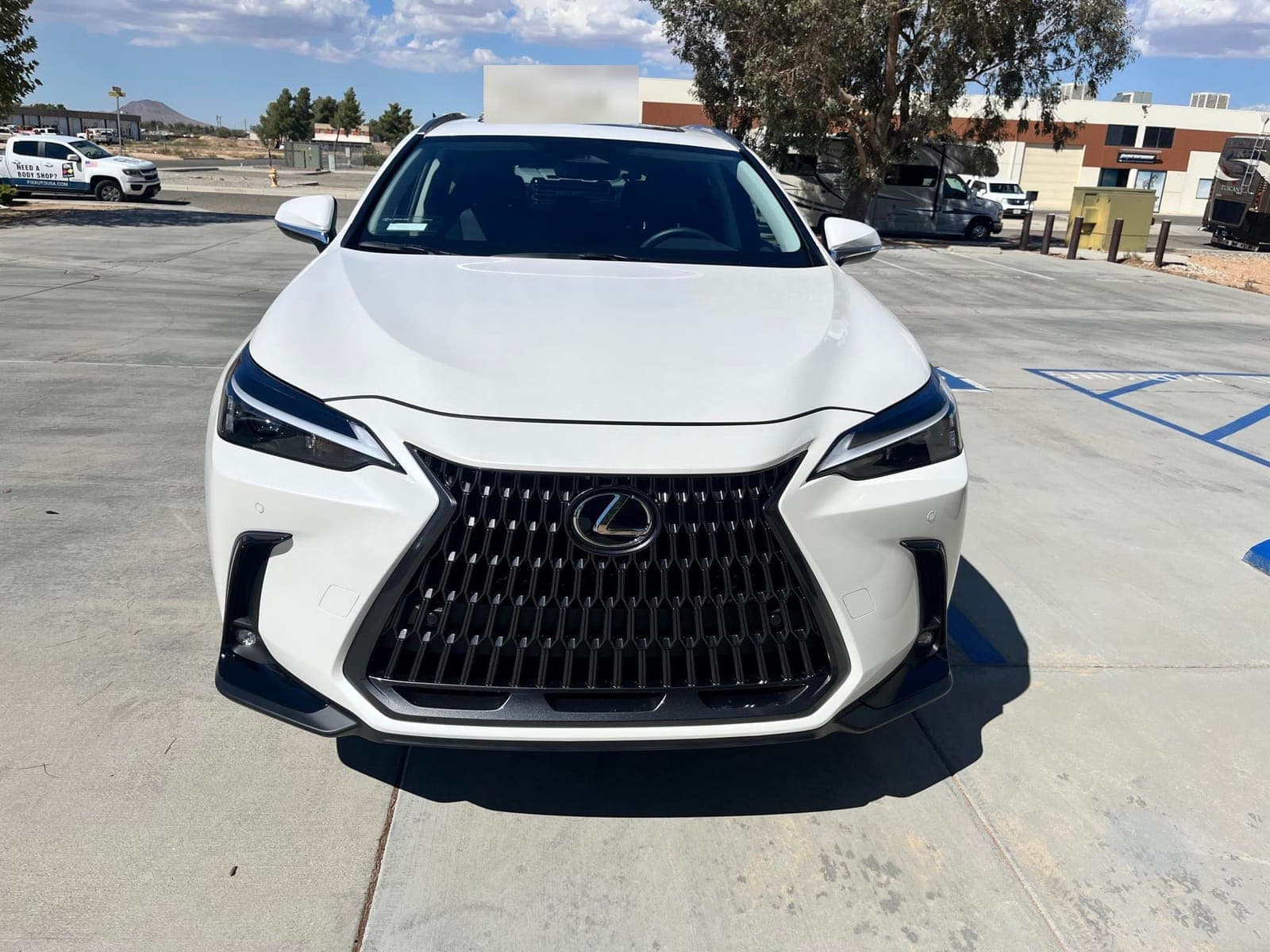 The same white Lexus NX after repair, with a straight hood and new grille and bumper