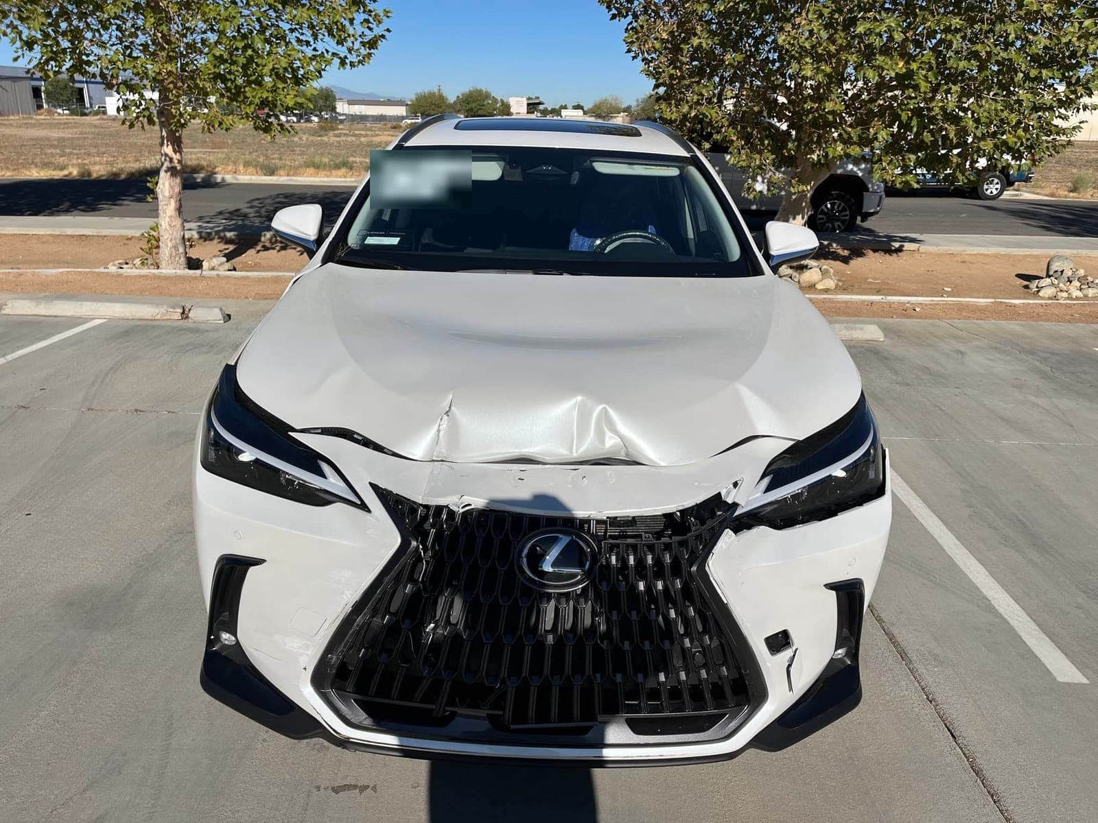 White Lexus NX with a crushed hood, broken grille, and damaged front bumper